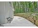Backyard with a bench, rock wall, concrete patio, and natural setting at 135 Adams Park Dr, Fayetteville, GA 30214