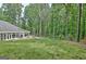 Expansive backyard featuring a well-maintained lawn and lush greenery and a sunroom with lots of windows at 135 Adams Park Dr, Fayetteville, GA 30214