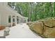 Backyard patio featuring a concrete patio, stone landscaping, and access to the wooded area at 135 Adams Park Dr, Fayetteville, GA 30214