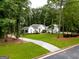 Beautifully landscaped white home with a circular driveway and lush green lawn at 135 Adams Park Dr, Fayetteville, GA 30214