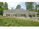 Exterior of home featuring a well-manicured lawn and white siding and a sunroom with many windows at 135 Adams Park Dr, Fayetteville, GA 30214