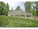 Exterior of home featuring a well-manicured lawn and white siding and a sunroom with many windows at 135 Adams Park Dr, Fayetteville, GA 30214