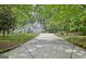 Stunning white home with arched windows, mature trees, and a long driveway, offering privacy and curb appeal at 135 Adams Park Dr, Fayetteville, GA 30214