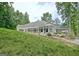 Exterior of home featuring a well-manicured lawn, white siding, sunroom, and covered patio at 135 Adams Park Dr, Fayetteville, GA 30214