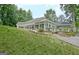 Exterior of home featuring a well-manicured lawn, white siding, sunroom, and covered patio at 135 Adams Park Dr, Fayetteville, GA 30214