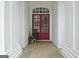 Inviting entryway with a striking red door, stone flooring, and decorative plants at 135 Adams Park Dr, Fayetteville, GA 30214