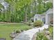 Beautifully landscaped front yard with a stone pathway leading to a charming white home at 135 Adams Park Dr, Fayetteville, GA 30214