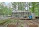 Greenhouse in backyard surrounded by planted garden beds and a fenced in yard at 135 Adams Park Dr, Fayetteville, GA 30214