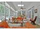 Bright sunroom features floor-to-ceiling windows, a skylight, and comfortable orange sofas for relaxing at 135 Adams Park Dr, Fayetteville, GA 30214