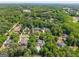 Aerial view of a neighborhood showcasing homes surrounded by mature trees and green spaces at 204 Clear Springs Ln, Peachtree City, GA 30269