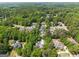 Aerial view of an estate nestled among mature trees in a lush landscape with other luxury homes nearby at 204 Clear Springs Ln, Peachtree City, GA 30269