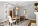 Dining room featuring a light color palette, fireplace, chandelier, large windows, and hardwood floors at 204 Clear Springs Ln, Peachtree City, GA 30269
