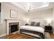 Relaxing main bedroom with a stone fireplace and a decorative white chandelier overhead at 204 Clear Springs Ln, Peachtree City, GA 30269