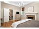 Warm main bedroom with fireplace, white bedding, and ensuite bathroom at 204 Clear Springs Ln, Peachtree City, GA 30269