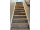 Carpeted staircase with white trim and a wooden handrail leading to the upper level of the home at 495 Mcgiboney Ln, Covington, GA 30016