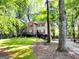 Charming two-story home with red shutters and a well-manicured lawn, surrounded by mature trees at 110 Cedar Creek Ct, Fayetteville, GA 30215