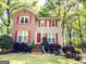 Front elevation of home with brick and vinyl siding, red shutters, and landscaped yard at 110 Cedar Creek Ct, Fayetteville, GA 30215