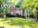 Charming two-story home featuring lush, green front yard and surrounded by mature trees at 110 Cedar Creek Ct, Fayetteville, GA 30215