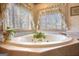 Close up of a bathroom jacuzzi tub surrounded by neutral tiling at 3341 Deer Hollow Sw Trl, Conyers, GA 30094