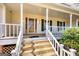 Welcoming covered front porch with wooden stairs and white railing at 3341 Deer Hollow Sw Trl, Conyers, GA 30094