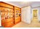 Hallway featuring built in wooden bookshelf running the length of the wall and tan carpet at 3341 Deer Hollow Sw Trl, Conyers, GA 30094