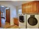 Practical laundry room with modern appliances and wooden cabinets at 3341 Deer Hollow Sw Trl, Conyers, GA 30094