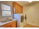 Functional laundry room with sink, washer, dryer and wooden cabinets at 3341 Deer Hollow Sw Trl, Conyers, GA 30094