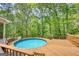 Above-ground pool with a surrounding wooden deck and serene wooded views at 3341 Deer Hollow Sw Trl, Conyers, GA 30094