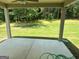 Covered back porch with view of the green backyard and adjacent trees at 165 Jodi Pl, Locust Grove, GA 30248