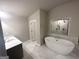 Modern bathroom featuring a soaking tub with tile surround and separate sink at 165 Jodi Pl, Locust Grove, GA 30248