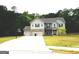 Charming two-story home featuring a three-car garage, well-maintained lawn, and a basketball hoop on the driveway at 165 Jodi Pl, Locust Grove, GA 30248