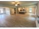 Open floor plan featuring a living room with sleek flooring, ceiling fan, and flows into a kitchen with gray cabinetry at 165 Jodi Pl, Locust Grove, GA 30248