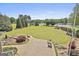 Expansive backyard features lush green lawn, patio with seating, and scenic view of the golf course and lake at 780 Birkdale Dr, Fayetteville, GA 30215