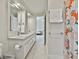 Bright bathroom features a double vanity, framed mirrors, tile floors, and updated fixtures, with a shower behind a glass door at 780 Birkdale Dr, Fayetteville, GA 30215