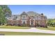 Stately brick home boasts a manicured lawn and a circular driveway, exuding curb appeal at 780 Birkdale Dr, Fayetteville, GA 30215
