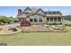 Rear exterior featuring a stone patio, landscaped garden, and a lush lawn at 780 Birkdale Dr, Fayetteville, GA 30215