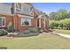 Charming brick home with a covered front porch, featuring manicured landscaping and stone accents at 780 Birkdale Dr, Fayetteville, GA 30215