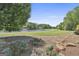 Picturesque golf course view with a pond, walking path, and manicured landscaping at 780 Birkdale Dr, Fayetteville, GA 30215
