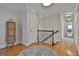Upstairs hallway with hardwood floors, decorative rug and display cabinet near the stairwell at 780 Birkdale Dr, Fayetteville, GA 30215