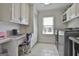 Well-lit laundry room features a built-in desk area, ample cabinet storage, and modern appliances at 780 Birkdale Dr, Fayetteville, GA 30215