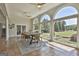 A sunlit dining area with a large table and floor-to-ceiling windows offers stunning views of the expansive backyard at 780 Birkdale Dr, Fayetteville, GA 30215