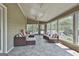 Covered patio features comfortable seating areas with neutral tones and multiple windows for natural light at 780 Birkdale Dr, Fayetteville, GA 30215