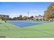 Community tennis courts with green and blue surfaces, overhead lighting, and surrounding landscaping at 780 Birkdale Dr, Fayetteville, GA 30215