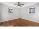 Bright bedroom featuring hardwood floors, ceiling fan, and a pair of windows for natural light at 1120 Starline Dr, Smyrna, GA 30080