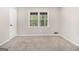 Neutral bedroom featuring large window and neutral carpet at 20 King Pl, Stockbridge, GA 30281