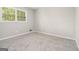 Neutral carpeted bedroom with a bright window at 20 King Pl, Stockbridge, GA 30281