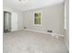 View of carpeted bedroom with neutral walls, bright window, and entry to en-suite bathroom at 20 King Pl, Stockbridge, GA 30281