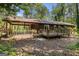 Rear view of home with covered porch, wooden deck, wooden siding, and wooded backyard at 20 King Pl, Stockbridge, GA 30281