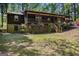 Rustic cabin-style home with charming front porch, brick foundation, and lush green lawn at 20 King Pl, Stockbridge, GA 30281