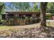 Rustic cabin-style home featuring a charming front porch and mature trees on a wooded lot at 20 King Pl, Stockbridge, GA 30281